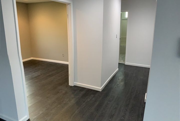 a house bedroom newly painted with gray walls and white trims, also with luxury vinyl flooring