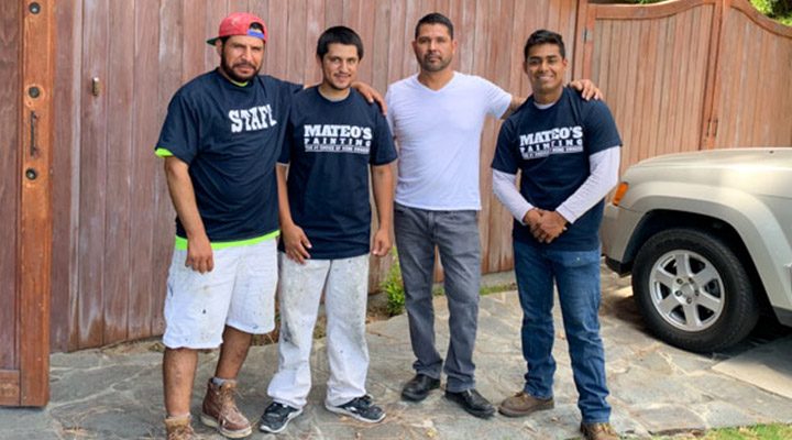 photo of Mateo's Construction team standing in front of the wooden gate
